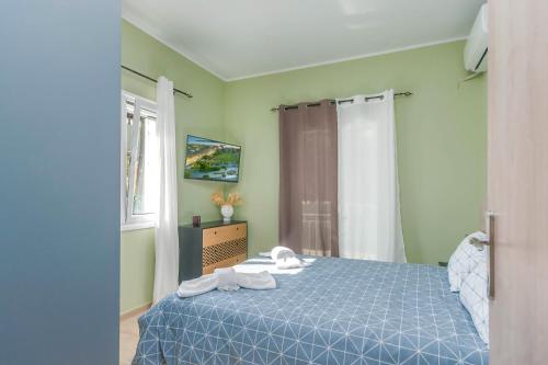 een slaapkamer met een blauw bed en een raam bij Patelis House in Potamós