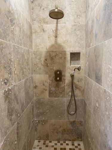 La salle de bains est pourvue d'une douche avec un pommeau de douche. dans l'établissement Villa de charme avec piscine, à Sotta