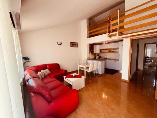 a living room with a red couch and a table at Ani Apartments in Umag