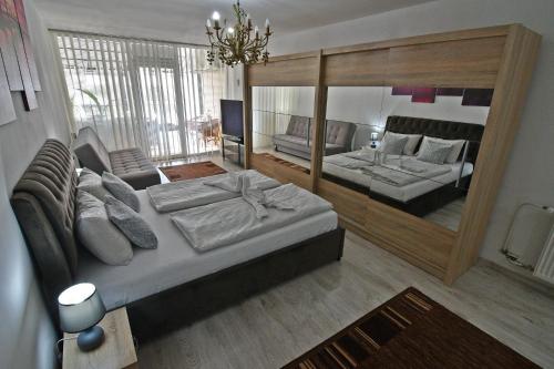 a bedroom with a bed and a couch and a mirror at Apartmany Zemplinska Širava Timea in Kaluža