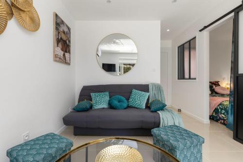 a living room with a couch and a mirror at CAP eureka SUN in Cap d'Agde