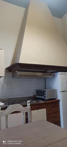 eine Küche mit einer Theke, einer Mikrowelle und einem Kühlschrank in der Unterkunft CASA SUL TORRENTE in Rocchetta Nervina