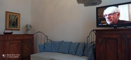 ein Wohnzimmer mit einem Sofa und einem Flachbild-TV in der Unterkunft CASA SUL TORRENTE in Rocchetta Nervina