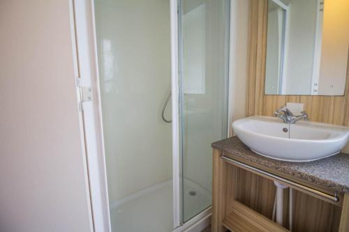 a bathroom with a sink and a shower at Modern Caravan With Wifi At Martello Beach Holiday Park In Essex Ref 29015sv in Clacton-on-Sea
