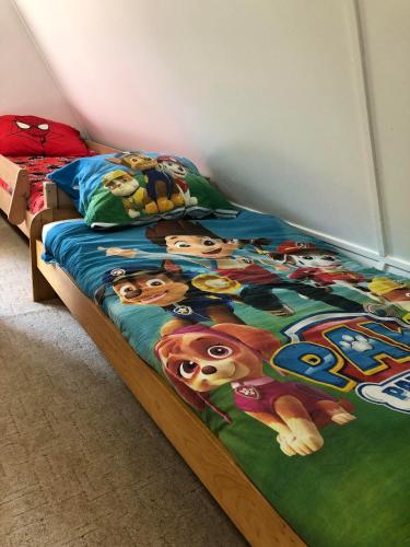 a bedroom with a bed with a disney movie blanket at Mókus Vendégház in Doboz