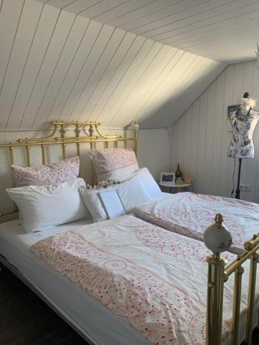 a bedroom with a large bed with pink and white pillows at Wellness am Wald Wellness Behandlungen & Frühstück Auszeit im Odenwald in Mörlenbach