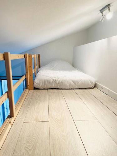 Joli Petit Studio Cosy في مارينيان: غرفة نوم بسرير وارضية خشبية