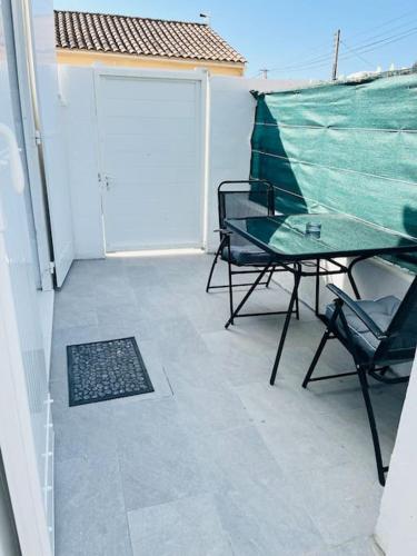 een patio met een tafel en stoelen en een deur bij Joli Petit Studio Cosy in Marignane