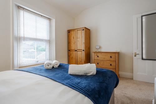 a bedroom with a large bed with towels on it at Wrea Cottage, 2 Bedrooms WiFi & Parking near Ribby Hall in Wrea Green