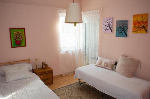 a bedroom with two beds and a window at Indigo in Rafina