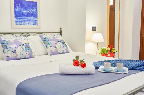 a bed with two towels and two cups on it at Appartamenti Rosa Dei Venti in Trapani
