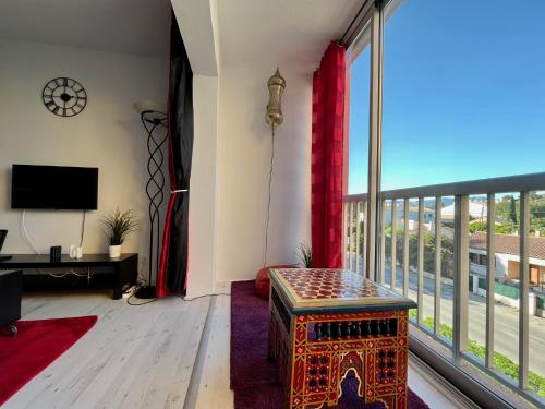 un salon avec une grande fenêtre et une table dans l'établissement Appartement résidence LA FREGATE - Pin Roland, à Saint-Mandrier-sur-Mer