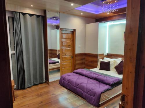 - une chambre avec un lit violet et un miroir dans l'établissement Shimla Abode, à Shimla