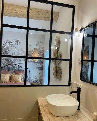 a bathroom with a white sink in front of a window at Appartement de prestige à Saint-Rémy-de-Provence in Saint-Rémy-de-Provence