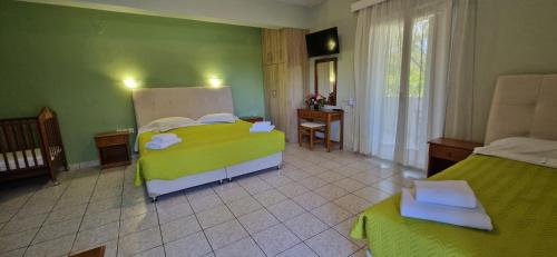 a bedroom with two beds and a table and a window at Christina Studios in Lygia