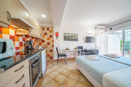 a kitchen and a bedroom with a bed in a room at Apartamentos Solar do Sol in Albufeira