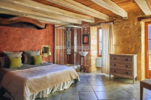 ヴィトラックにあるLa Maison Bleue - Gîte de Charme en Périgordの木製の天井が特徴のベッドルーム1室(大型ベッド1台付)