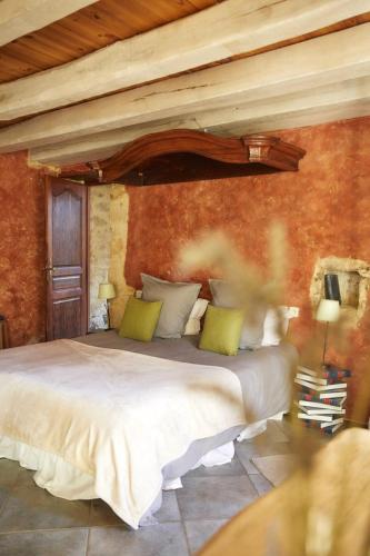 a bedroom with a large white bed with green pillows at Domaine de Cantegrel - Gîtes de Charme et Suite Troglodyte en Périgord in Vitrac
