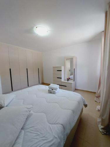 1 cama blanca grande en una habitación con espejo en Villa Daniela, en Loutraki