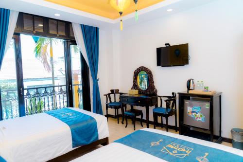 a bedroom with two beds and a tv and a balcony at iHome Hoi An in Hoi An