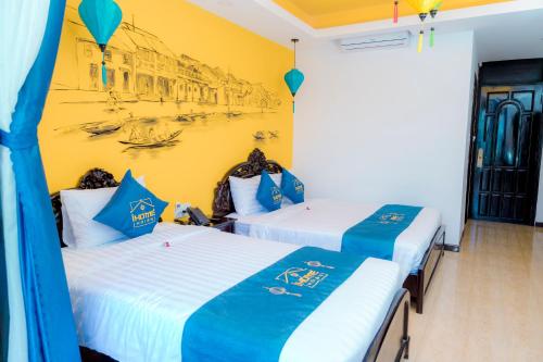 two beds in a room with a painting on the wall at iHome Hoi An in Hoi An
