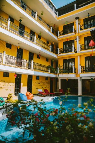 a hotel with a swimming pool in front of a building at iHome Hoi An in Hoi An