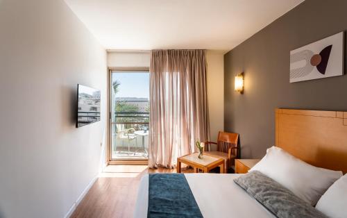 a hotel room with a bed and a window at Jacob Eilat in Eilat