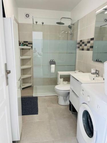 W łazience znajduje się umywalka i pralka. w obiekcie Maison 4 personnes avec jacuzzi w mieście Marignane