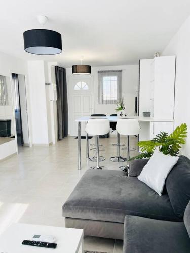 un salon avec un canapé et une table dans l'établissement Maison 4 personnes avec jacuzzi, à Marignane