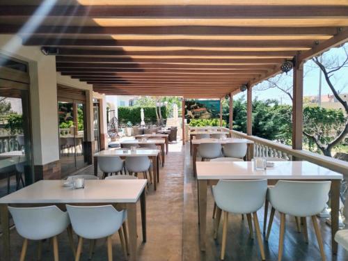 a restaurant with tables and chairs on a balcony at Garden in Limenaria