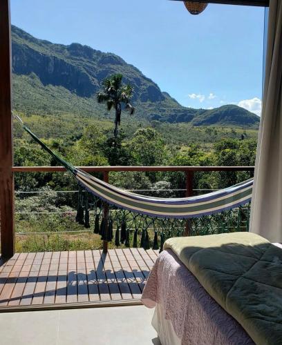 a hammock on a balcony with a view of the mountains at Pousada Rancho dos Ipês in Alto Paraíso de Goiás