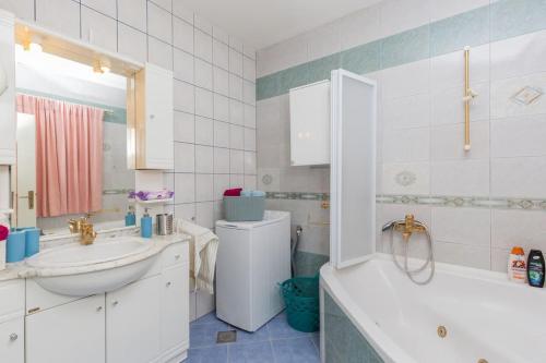 Doa - Apartment with Lovely Terrace & Sea View في مْليني: حمام مع حوض ومرحاض وحوض استحمام