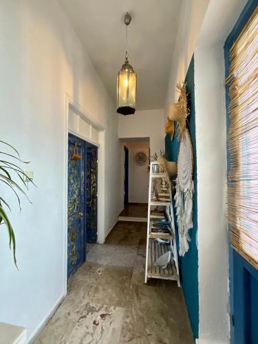 a hallway with blue and white walls and a blue door at Chez Cécile Home in Mochlos