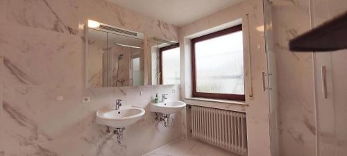 バーリンゲンにあるStilvolles Haus 124 qmのバスルーム(洗面台2台、鏡、窓付)