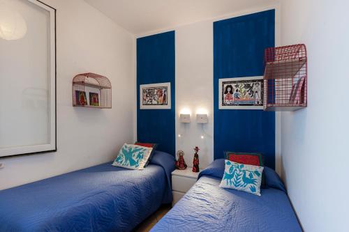 2 łóżka w pokoju z niebieskimi ścianami w obiekcie Villa Vivimar w Syrakuzach