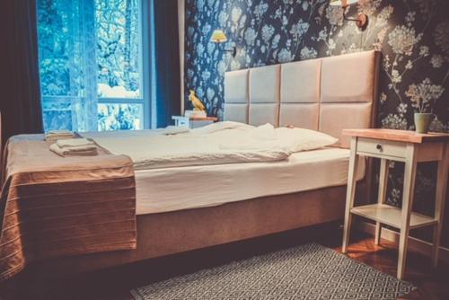 a bedroom with a bed and a table and a window at cdn Pokoje in Lublin