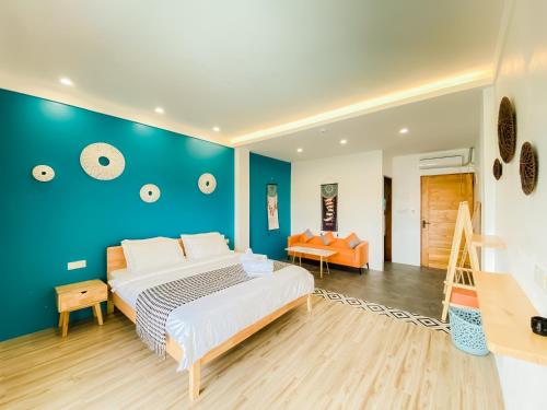 um quarto com uma cama grande e uma parede azul em Holabay Resort em Panglao