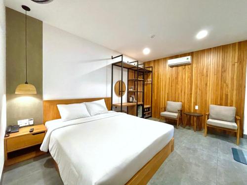a bedroom with a large bed and a desk and chair at Coast House Boutique Hotel in Nha Trang
