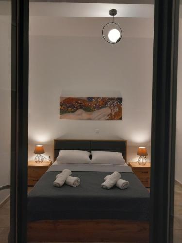 a bedroom with a bed and a painting on the wall at Aurora Andros House in Korthi