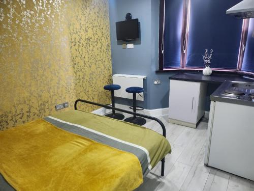 um quarto de hospital com uma cama e dois bancos em Dodi Apartment em Londres