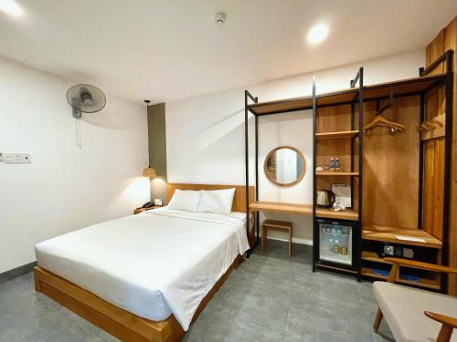 a bedroom with a large white bed and a mirror at Coast House Boutique Hotel in Nha Trang