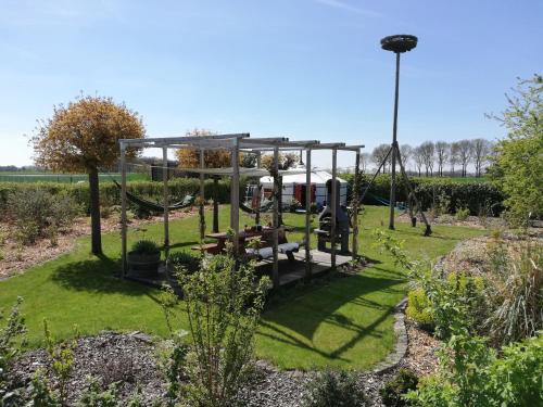 un parque con parque infantil con columpio en T'eiberveld Yurt verhuur Noord-Sleen en Noord-Sleen