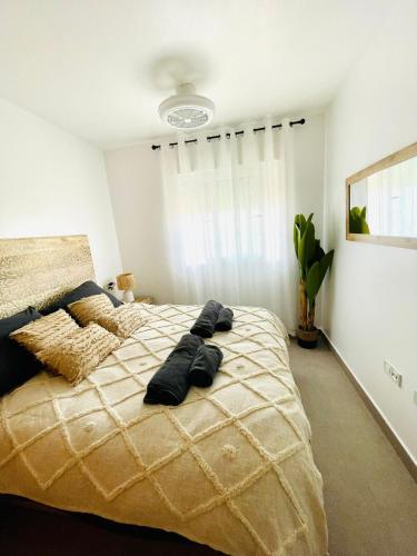 una camera da letto con un grande letto con due cuscini sopra di Apartamento El Osito a La Manga del Mar Menor