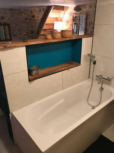 une baignoire blanche dans une salle de bain avec un lavabo dans l'établissement Du haut des remparts, à Brigueuil