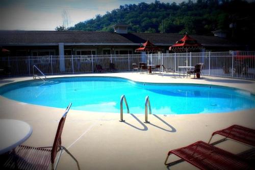 une grande piscine avec deux chaises et une table dans l'établissement Cherokee Grand Hotel, à Cherokee