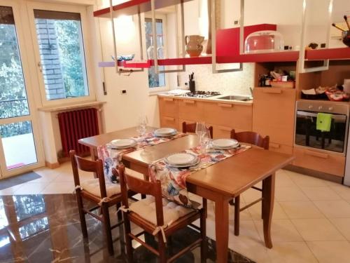 a kitchen with a wooden table with chairs and a dining room at House in the Mountains - greenery near Verona in Cerro Veronese