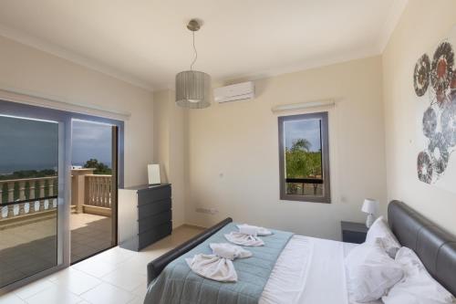 sypialnia z łóżkiem i balkonem w obiekcie Sparta Luxury Villa w mieście Protaras