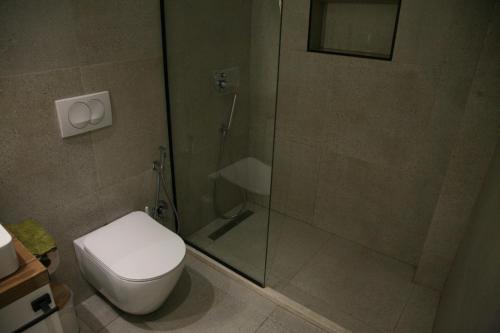 a bathroom with a toilet and a glass shower at 4SeasonsGea , Cozy Studio In Central Position , Tirana in Tirana