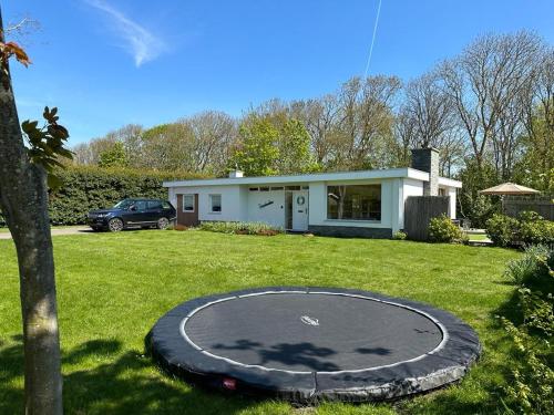 a trampoline in the yard of a house at Family bungalow with garden for 6-8 people in Cadzand