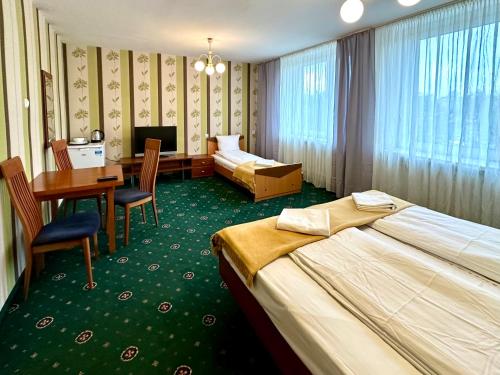 um quarto de hotel com duas camas e uma secretária em NARAMOWICE Hostel by Friendly Hostel em Poznań